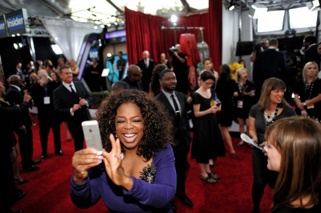 Oprah Winfrey takes a photo of photographers and fans on the red carpet at the 20th Annual Screen Actors Guild Awards  at the Shrine Auditorium in Los Angeles, California on Saturday January 18, 2014 (Photo by Hans Gutknecht / Los Angeles Daily News)