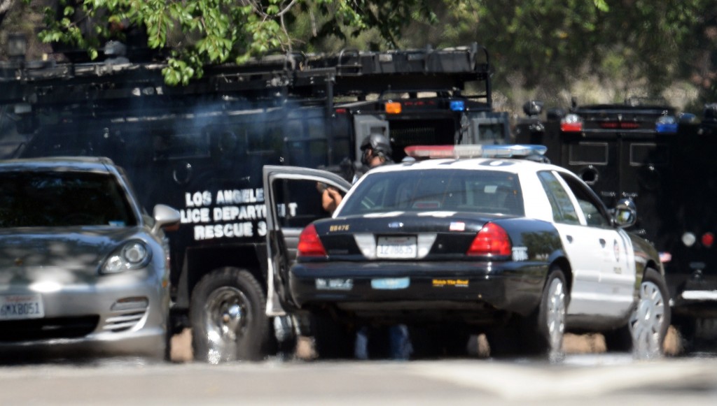 LAPD SWAT officers fire tear gas in to  a home in the 11500 block of Hartsook St. in Valley Village. A man with a rifle lead police on a car chase before exiting his vehicle with the rifle and fleeing in to the residential neighborhood. (Photo by Hans Gutknecht/Los Angeles Daily News)