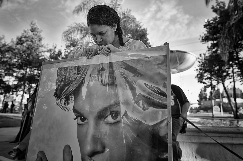 Jennifer Matthews, Culver City, prays while holding a poster of Prince during a vigil for the artist at Leimert Plaza Park.    (Photo by Hans Gutknecht/Los Angeles Daily News)